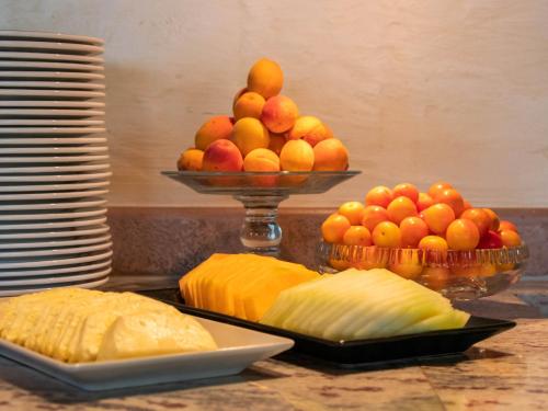 a table with a bowl of fruit and a plate of bread at Hotel-Restaurant Le Mont Paisible, Crans-Montana in Crans-Montana