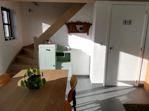 une salle à manger avec une table en bois et un escalier dans l'établissement Noest, à Destelbergen