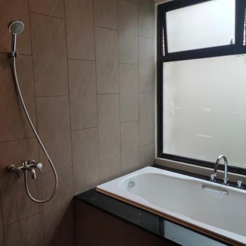 a bathroom with a shower and a sink and a window at vila vimala hills in Bogor