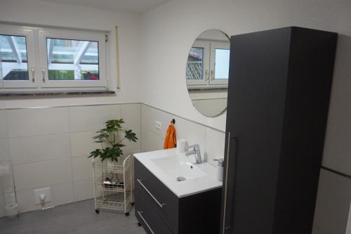 y baño con lavabo y espejo. en Ferienwohnung Auszeit Zwiefalten en Zwiefalten