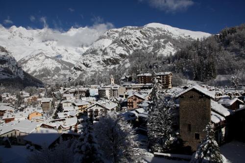 a town covered in snow with mountains in the background at Grand Hotel Royal E Golf in Courmayeur