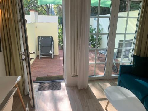 a living room with a door open to a patio at Park-Lodge Am Rohrbusch in Münster