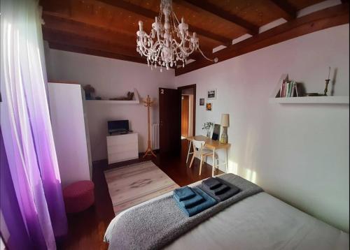 een slaapkamer met een bed en een kroonluchter bij In Corte al Laghetto in Merate