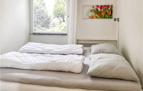 ユリアーナドルプにあるBeautiful Home In Julianadorp With 3 Bedrooms And Wifiの白い枕2つ(1室のベッドに座る)