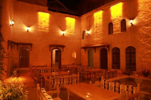 una habitación con mesas y sillas en un edificio en Aslan Guest House, en Sanlıurfa