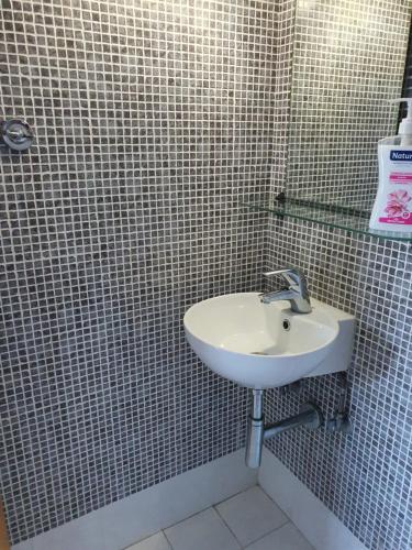 a bathroom with a sink and a tiled wall at Anny's studio in Chalkida