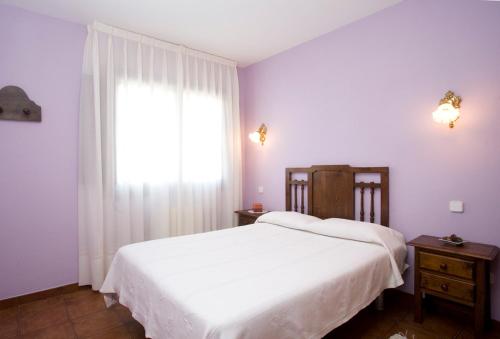 a bedroom with a white bed and a window at Hotel Rural Suquin in Navia