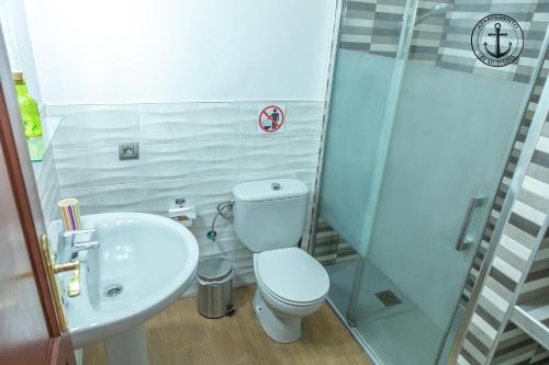a bathroom with a toilet and a sink and a shower at Apartamento El Muellito in Playa Blanca