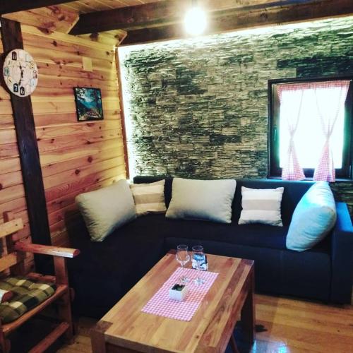 a living room with a blue couch and a table at Brvnara na bregu in Bajina Bašta
