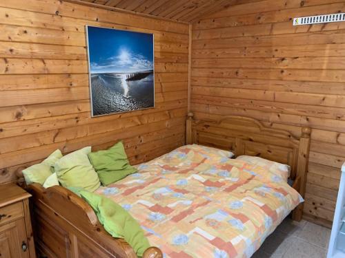 a bedroom with a bed in a log cabin at Camping Boetn Toen Pieterburen in Pieterburen