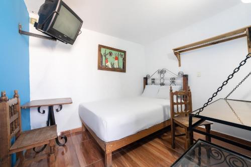 1 dormitorio con 1 cama y TV en la pared en OYO Casa Vieja,Ciudad Serdán,Museo La Magnolia en Ciudad Serdán