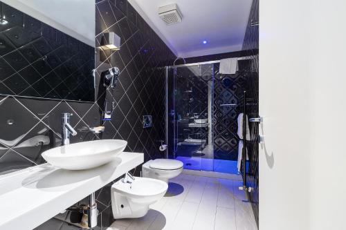 a bathroom with a sink and a toilet and a shower at Hotel Nazionale in Ferrara