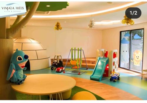 a childs play room with a table and a playground at vila vimala hills in Bogor