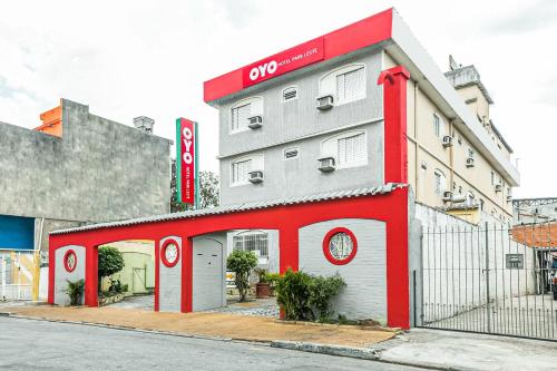 a red and white building on the side of a street at OYO Hotel Park Leste, São Paulo in Sao Paulo