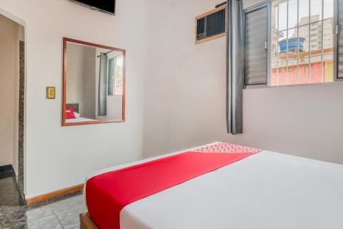 a bedroom with a red bench and a mirror at Hotel Park Leste, São Paulo in Sao Paulo
