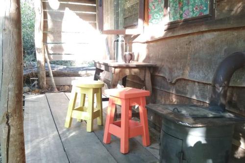 a porch with two stools and a table and a barrel at Vila Renata in Playa Hermosa