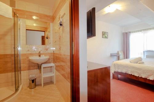 a bathroom with a shower and a sink and a bed at Willa Stożek, 50 m od term i wyciągów narciarskich in Białka Tatrzanska