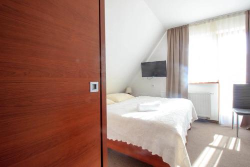 a bedroom with a bed next to a wooden door at Willa Stożek, 50 m od term i wyciągów narciarskich in Białka Tatrzanska