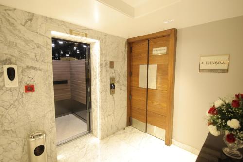 a bathroom with a shower and a glass door at Best Western Darbar Delhi in New Delhi