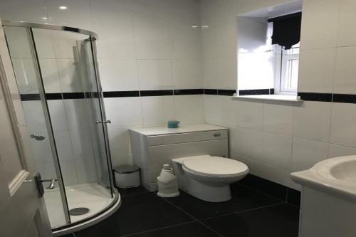 a bathroom with a toilet and a glass shower at The Old Rectory in Jarrow
