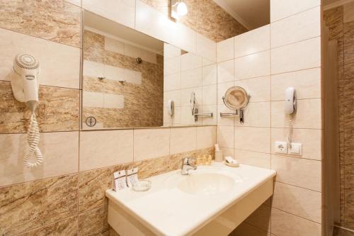 a bathroom with a sink and a shower and a phone at Hotel Retro in Novokuybyshevsk