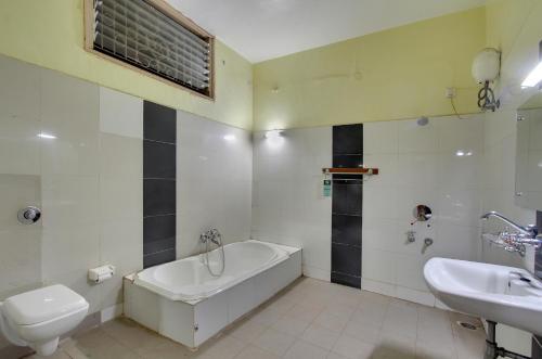 a bathroom with a tub and a toilet and a sink at Kanthi Resorts Badami in Bāgalkot