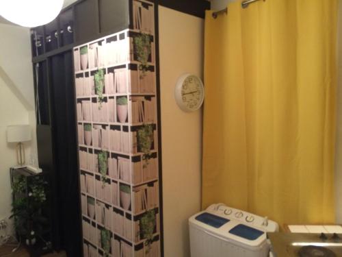 La salle de bains est pourvue de toilettes et d'une horloge murale. dans l'établissement Studio Cosy, à Paris