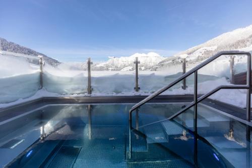 a hot tub with snow covered mountains in the background at 4*S Galtenberg Resort in Alpbach