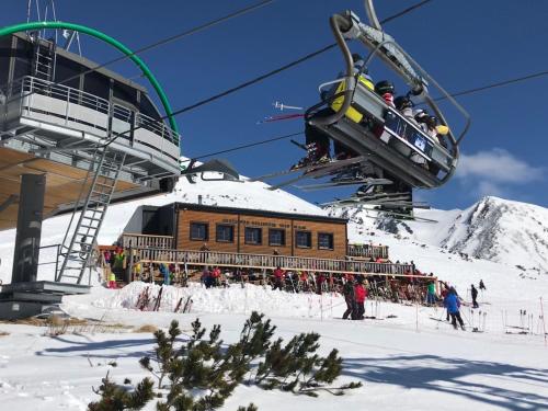 a ski lift with a ski lodge on a mountain at Horská Chata pod Soliskom in Vysoke Tatry - Strbske Pleso