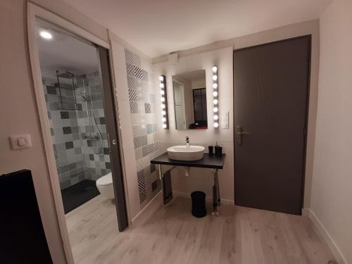 La salle de bains est pourvue d'un lavabo et d'un miroir. dans l'établissement SAKURA, à Fontaine-le-Comte