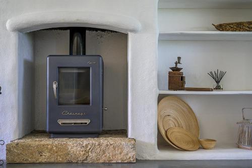 a wood stove in a room with a shelf at Villa Perla Blanca in Platánion