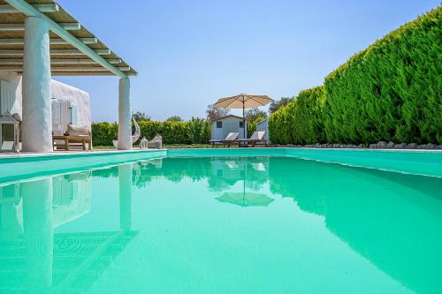 a swimming pool with blue water in a house at Villa Perla Blanca in Platánion