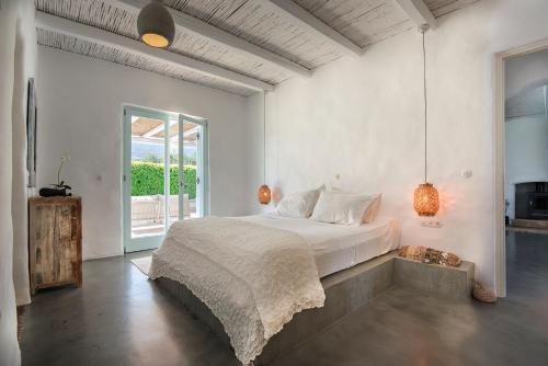 a bedroom with a bed and a large window at Villa Perla Blanca in Platánion