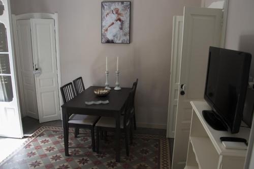 a dining room with a table and a television at Parva Domus in Modica