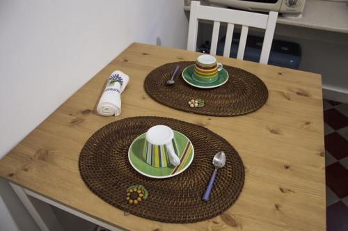 a wooden table with two hats and plates on it at Parva Domus in Modica