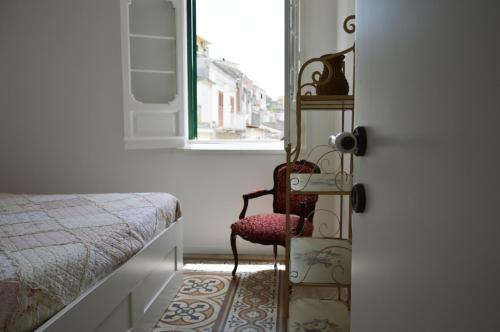 a bedroom with a chair and a bed and a window at Parva Domus in Modica