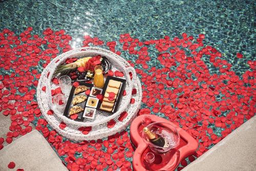 a pool with a basket of candies next to a bowl at Palladium Hotel in Platis Yialos Mykonos