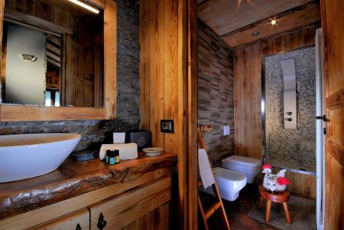 Aparthotel Foyer d'antan SUITE con caminetto hammam o vasca idromassaggio في بروسون: حمام مع حوض ومرحاض