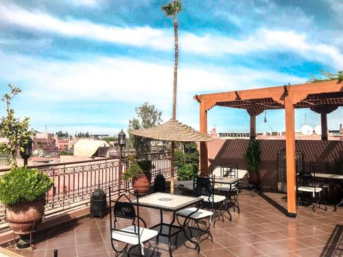 d'une terrasse avec des tables et des chaises sur un balcon. dans l'établissement Riad Hôtel Marraplace, à Marrakech