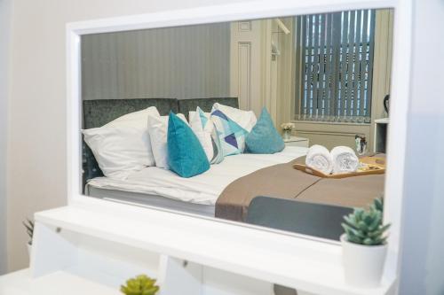 a reflection of a bed with blue pillows in a mirror at Castle View in Dudley
