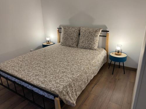 cottage Philippe et Valérie في Silly-en-Gouffern: غرفة نوم مع سرير وطاولتين