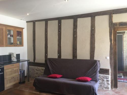 a room with a bed with red pillows on it at Gite a la ferme in Rouessé-Vassé