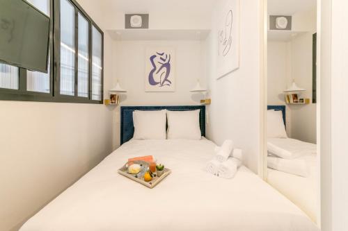 Cette petite chambre comprend un lit avec un bol de fruits. dans l'établissement WS Louvre - Richelieu, à Paris