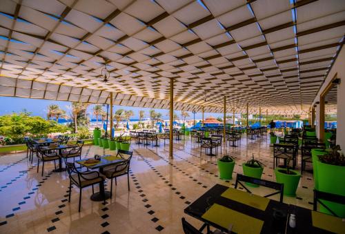 a restaurant with tables and chairs under a tent at Concorde Moreen Beach Resort in Abu Dabab