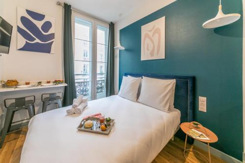 Apartments WS Louvre - Richelieu في باريس: غرفة نوم بها سرير عليه صينية طعام
