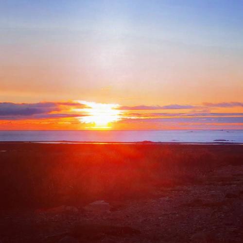 a sunset over the ocean with the sun in the sky at Bard Cottage in Akranes
