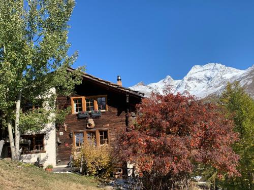 a log cabin with mountains in the background at Châlet Birkhahn in Saas-Fee