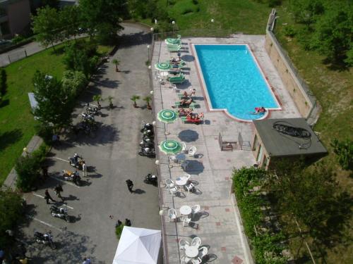 an overhead view of a swimming pool with chairs and umbrellas at Hotel Ducale in Tabiano