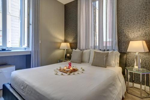 ローマにあるSpagna Boutiqueのベッドルーム1室(大きな白いベッド1台、窓2つ付)