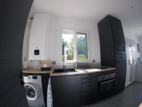 une cuisine avec un évier et une machine à laver dans l'établissement Sanarybeach, à Sanary-sur-Mer